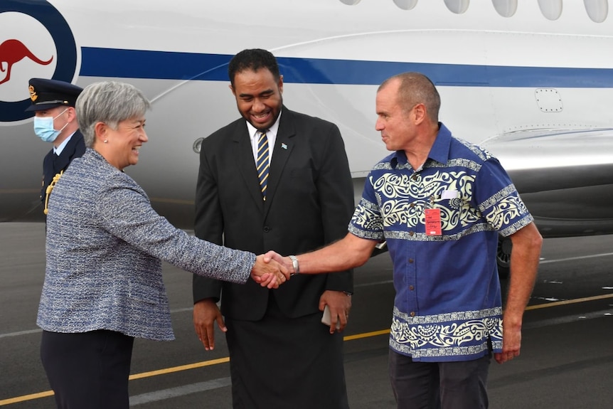 Australian Foreign Minister Penny Wong shakes hands on the tarmac after landing in Fiji. 