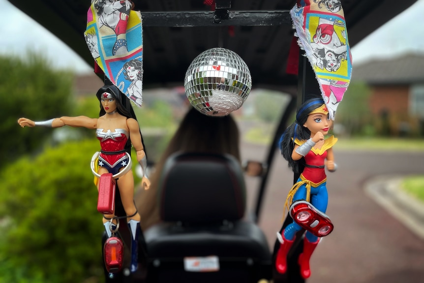Wonder Woman dolls hang from a mobility scooter