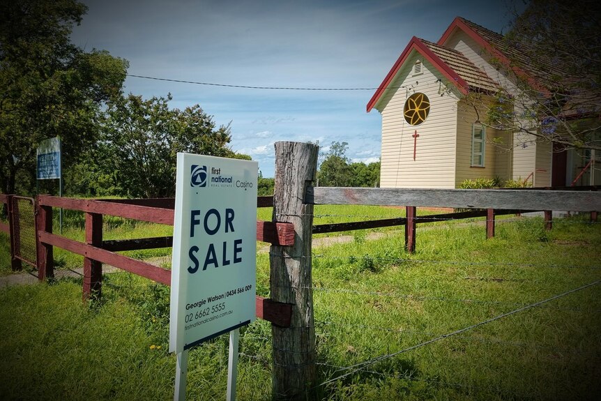 small church in country with for sale sign out the front
