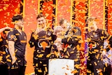 Confetti falls from the ceiling as the League of Legends team Mammoth hold their trophy at the Melbourne Esports Open.