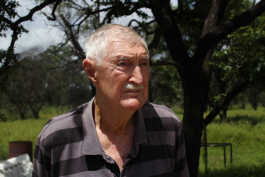 a close up of a man with trees in the background