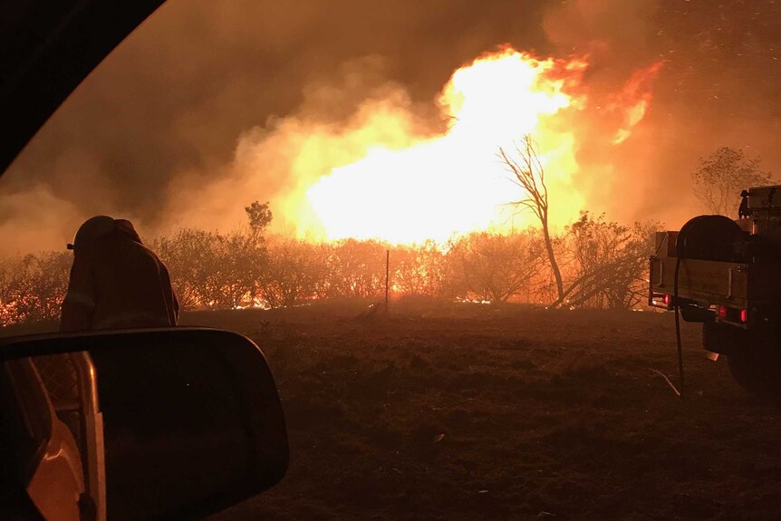 Flames of a bushfire shot through a car window near Mt Larcom