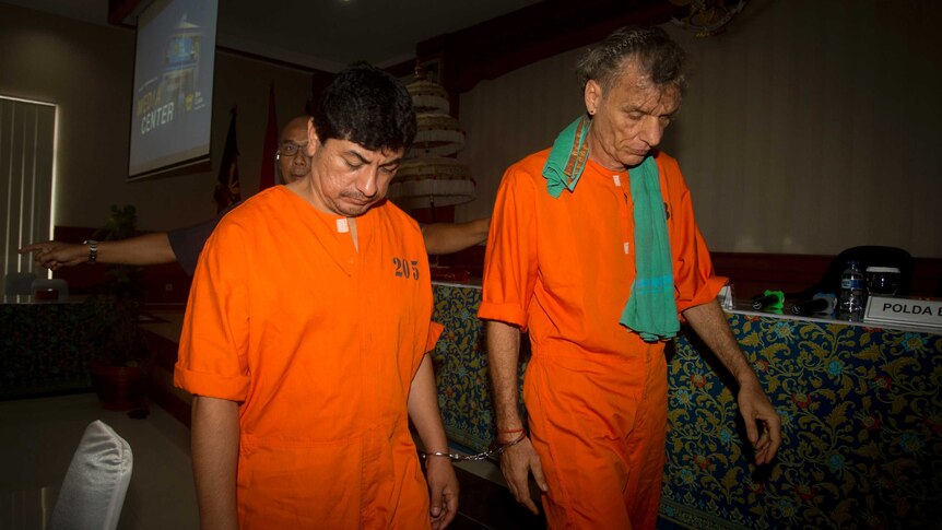 Accused drug smugglers Jorge Albornoz Gamarra Frank Zeldler, wear orange prison suits and walk with their heads bowed