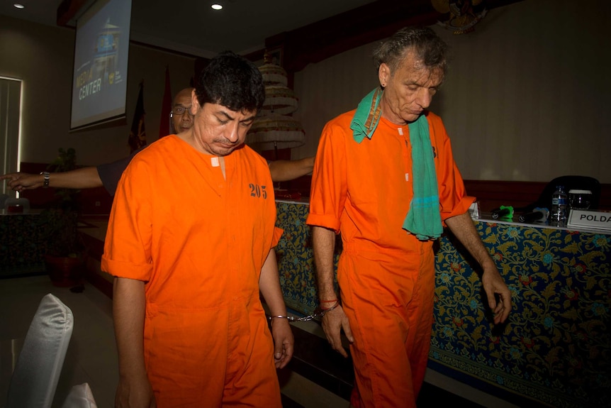 Accused drug smugglers Jorge Albornoz Gamarra Frank Zeldler, wear orange prison suits and walk with their heads bowed