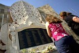 Tourists scan the names of victims at a Bali bomb monument in Kuta.