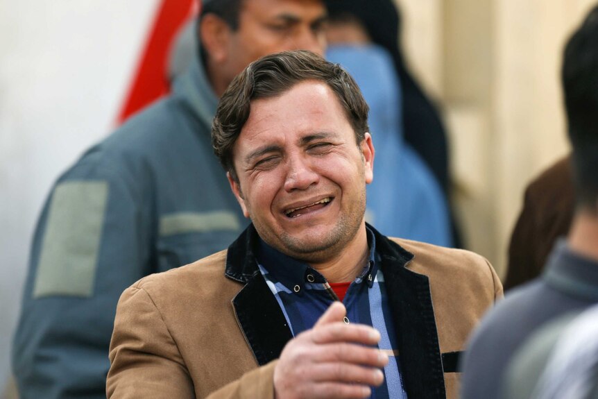 A man cries outside the hospital, waiting for news about loved ones.