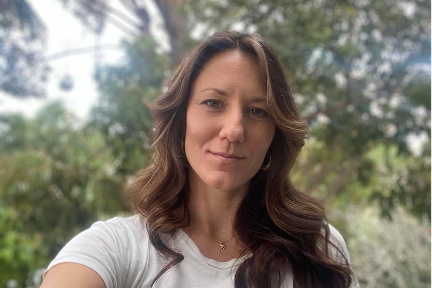 Mid shot of a caucasian woman smiling to the the camera in the outdoors