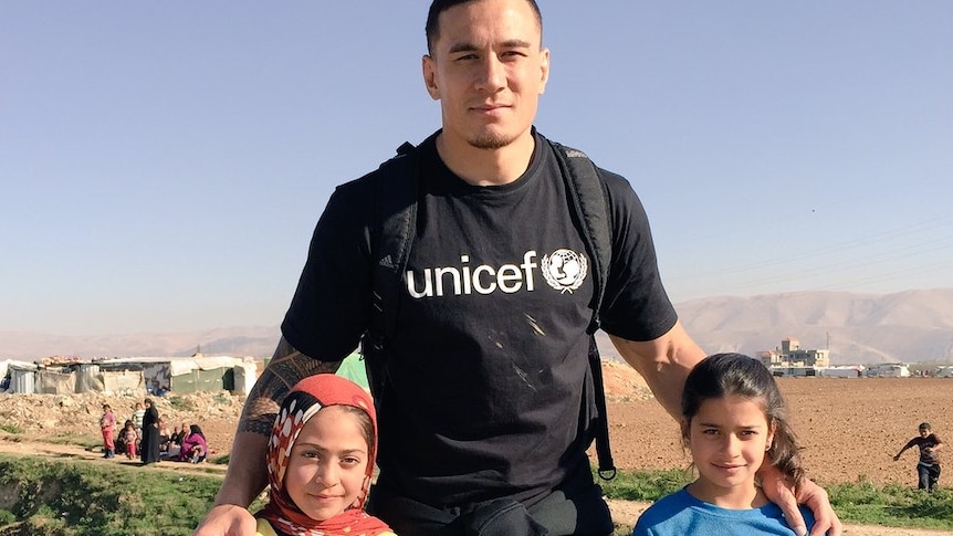 Sonny Bill Williams poses with two children during a trip to a Syrian refugee camp in Lebanon