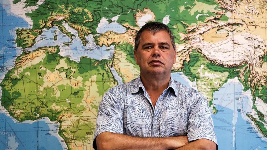 Cambridge Gulf Ltd chief executive Tony Chafer standing in front of a world map at his office in Kununurra