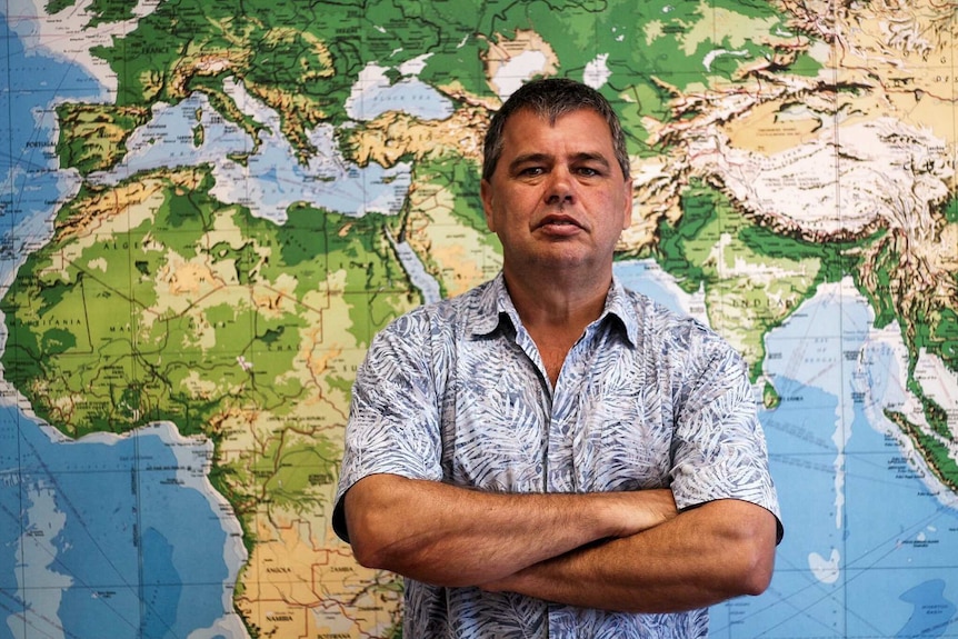 Cambridge Gulf Ltd chief executive Tony Chafer standing in front of a world map at his office in Kununurra