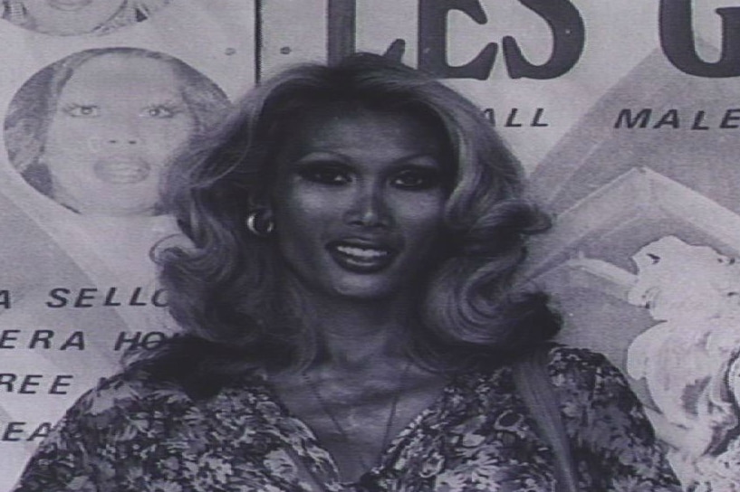 Ayesha poses in front of a poster for the Les Girls club in Kings Cross.