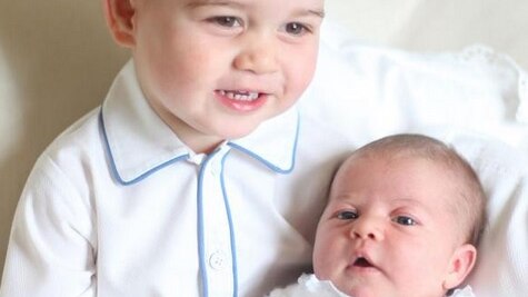 Prince George smiles as he is photographed with Princess Charlotte