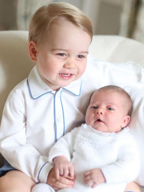 Prince George smiles as he is photographed with Princess Charlotte