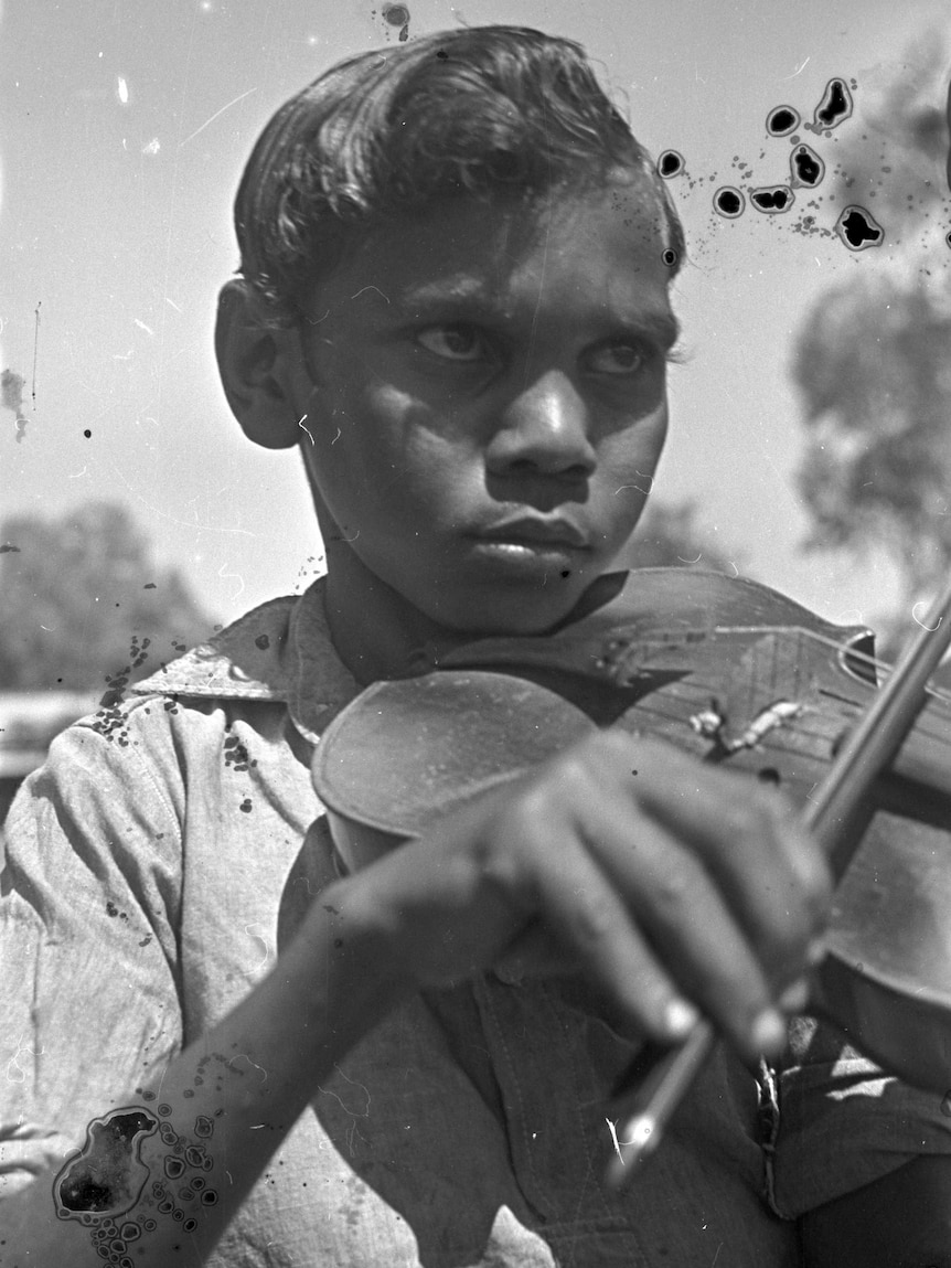 A young indigenous boy plays the violin at the Derby Leprosarium in 1948.