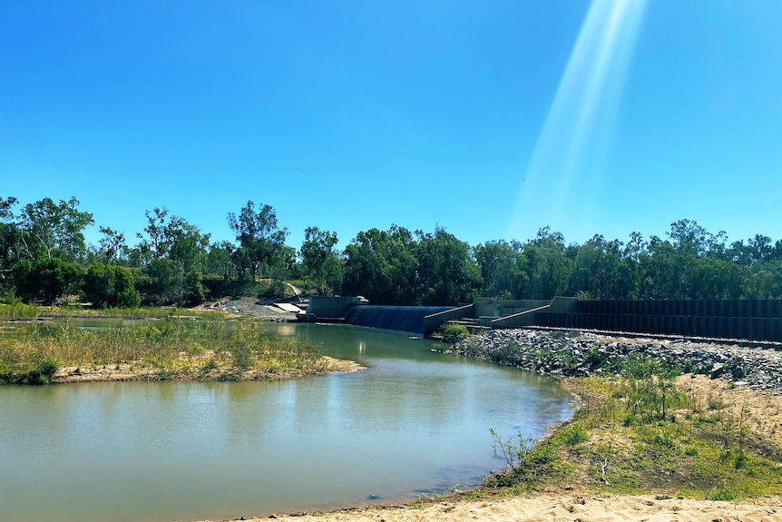 A bend in a river beneath a cloudless sky.