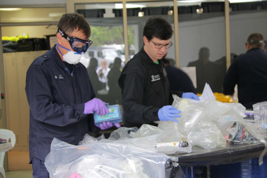 Forensic chemists sort through drug equipment