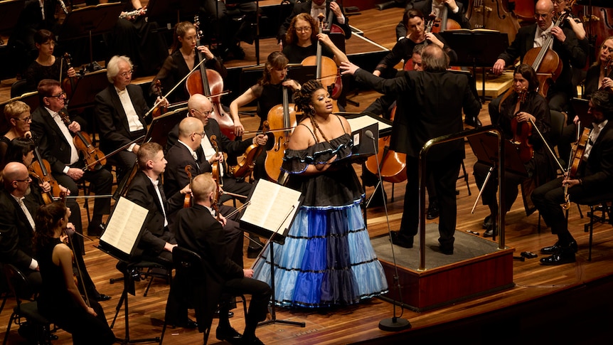 Mezzo-soprano Raehann Bryce Davis on stage at Hamer Hall in Melbourne singing with the Melbourne Symphony Orchestra.