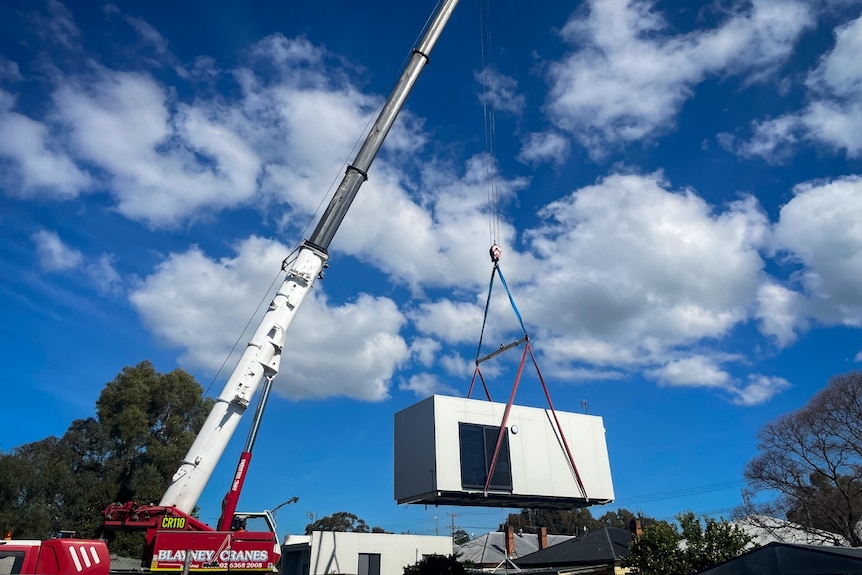 A crane moving a housing pod