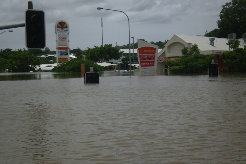 Floodwaters inundate roads and a suburban shopping centre at Fairfield.