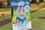 An election sign for Elizabeth Re with graffiti.