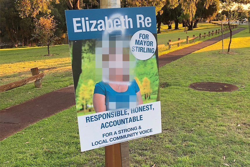 An election sign for Elizabeth Re with graffiti.