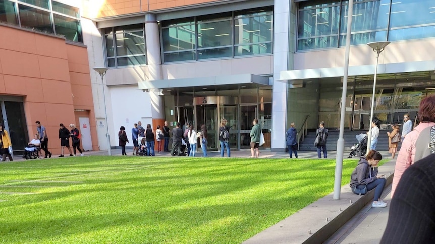 People lining up outside an official looking building