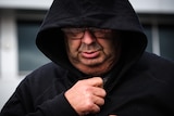 A man wearing glasses and a black hoodie