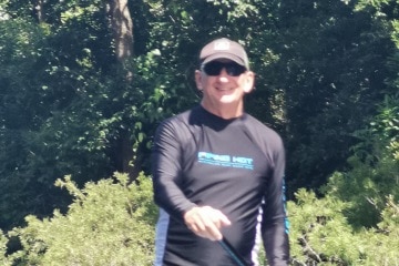 Middle-aged man on stand up paddle board on a rive in Far North Queensland.