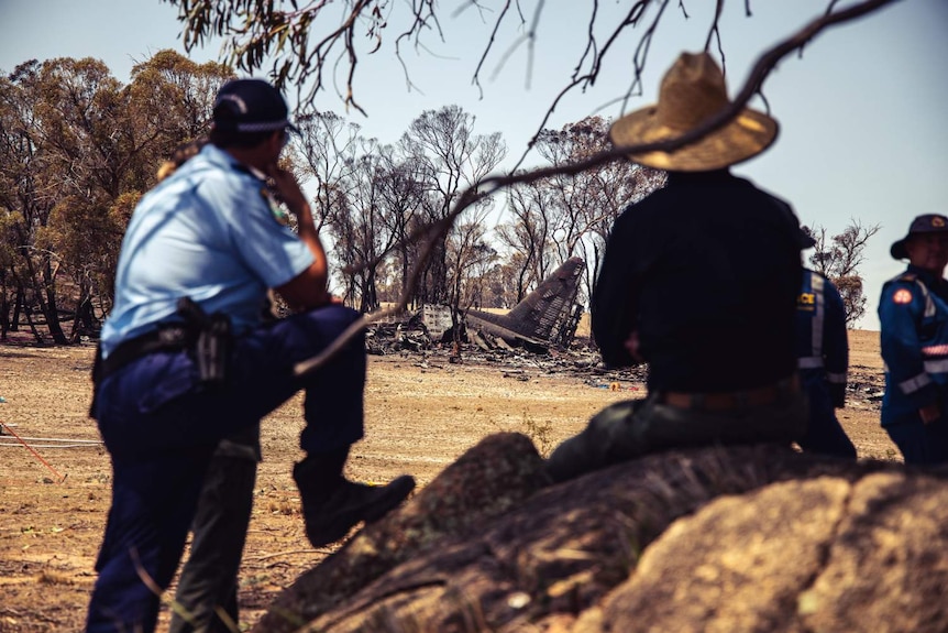 police observing the wreckage of a plane in bushland