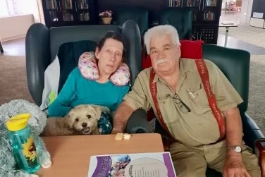 Two older people with a puppy.