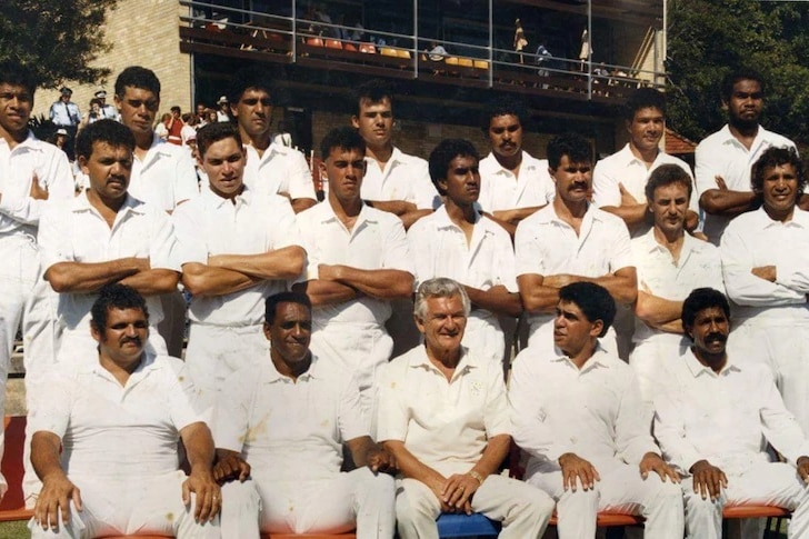 Команда по крикету стоит в белых одеждах с премьер-министром