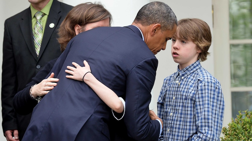 Barack Obama hugs relative of shooting victims after slamming 'minority' for blocking legislation.