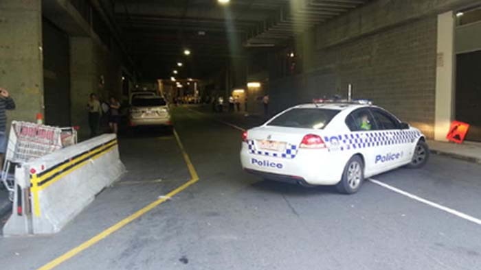A police car sits near the scene of a reported shooting near Docklands Stadium