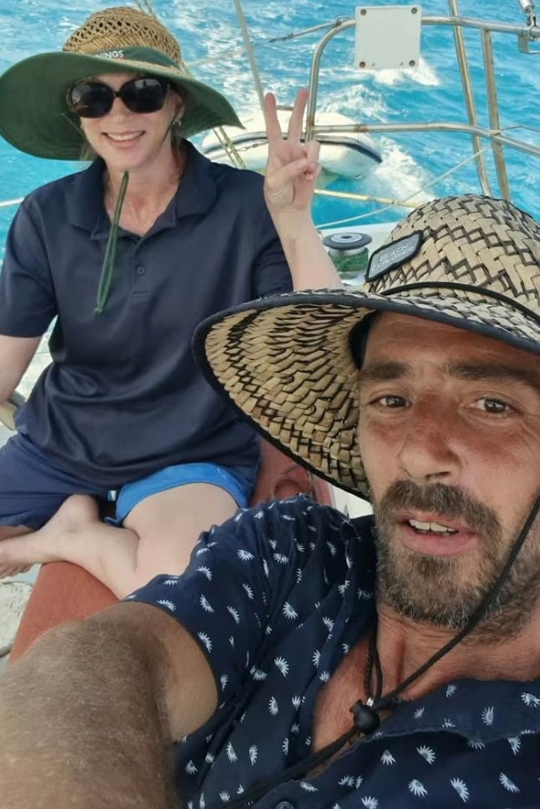 Un hombre y una mujer se hacen un selfie en una embarcación de tamaño mediano. 