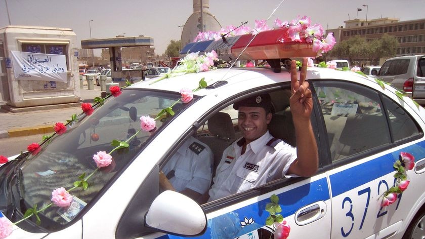 An Iraqi police officer sitting in his decorated police car in central Baghdad