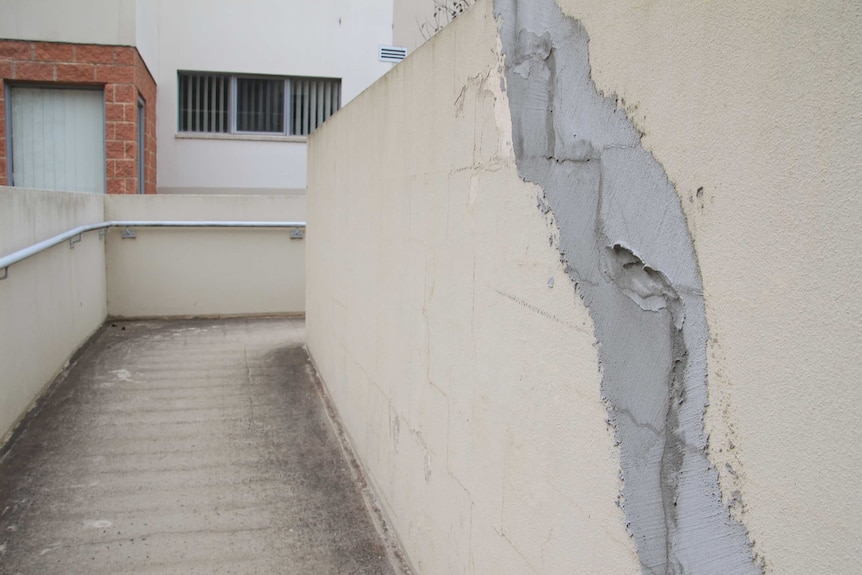 A large crack on a wall in a walkway at the complex.