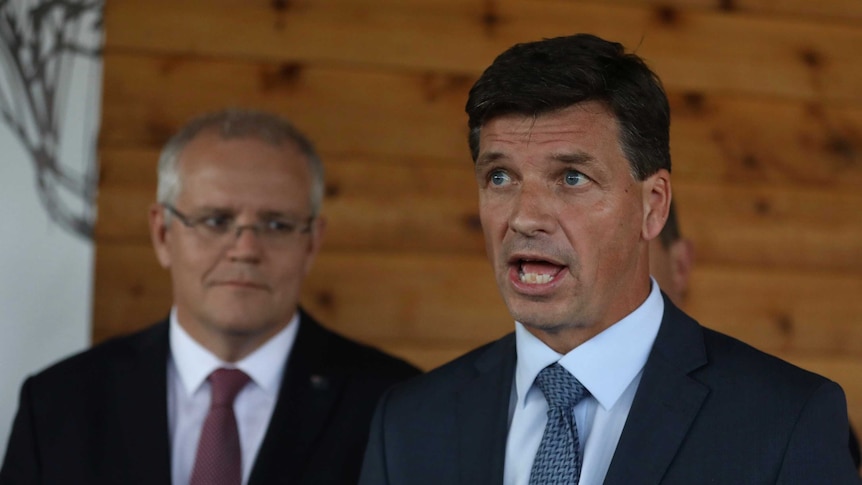 Mr Taylor looks to journalists, not pictured, as he answers questions at a press conference. Mr Morrison is standing behind him.