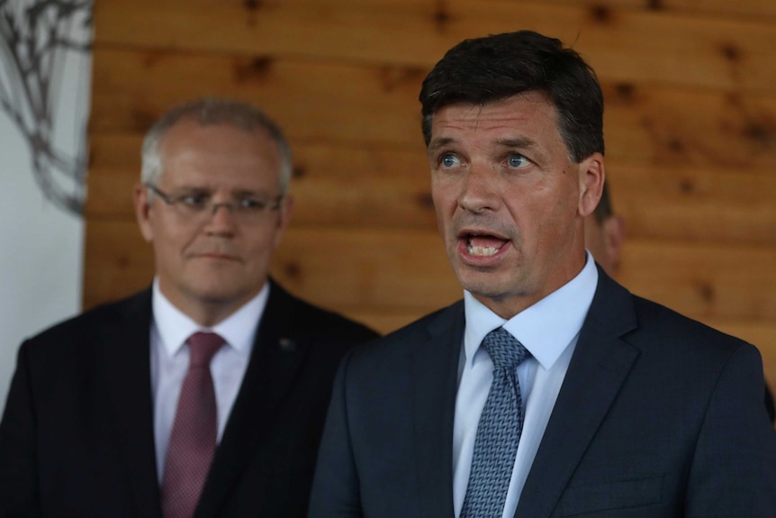 Mr Taylor looks to journalists, not pictured, as he answers questions at a press conference. Mr Morrison is standing behind him.