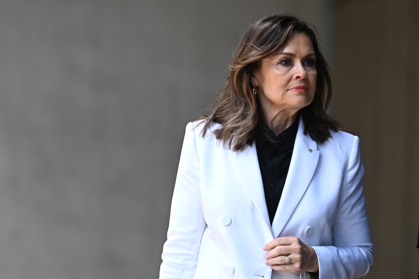 Lisa Wilkinson looks to the side in a white suit.