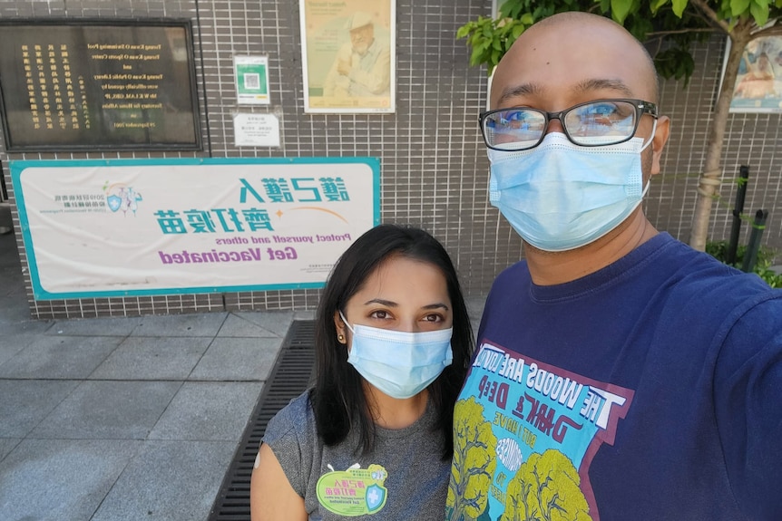 a woman and a man wearing masks taking a selfie