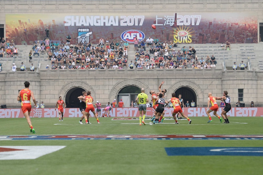 Gold Coast Suns and Port Adelaide Power play in front of a sign saying Shanghai 2017.