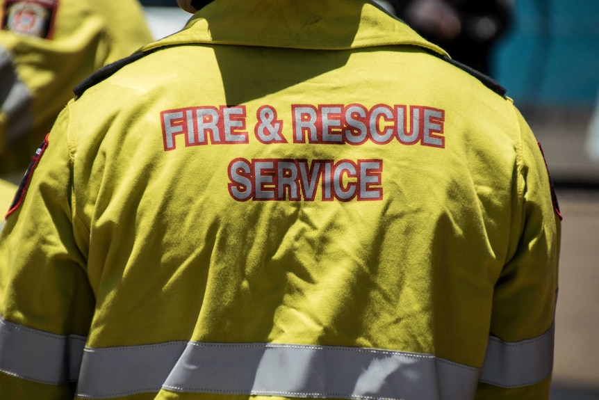 An unidentified firefighter wearing his high-vis work uniform with the words Fire and Rescue Service on the back.