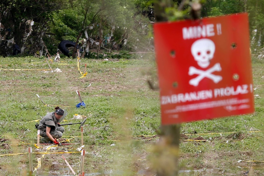 A member of the Armed Forces of Bosnia and Herzegovina demines an area near river Bosna in the city Visoko, May 20, 2014