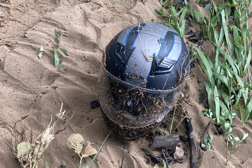 A helmet lying in some sand.
