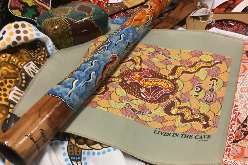 Collection of fake Aboriginal-style souvenirs, including a knock-off didgeridoo and canvas art work
