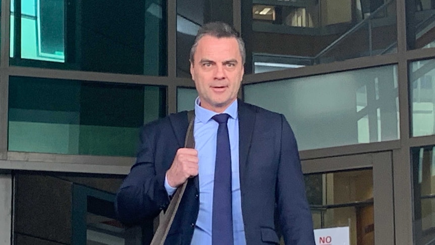 Stuart Bateson leaves the Melbourne Magistrates' Court in a blue suit.