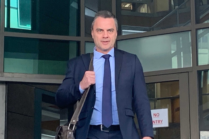 Stuart Bateson leaves the Melbourne Magistrates' Court in a blue suit.
