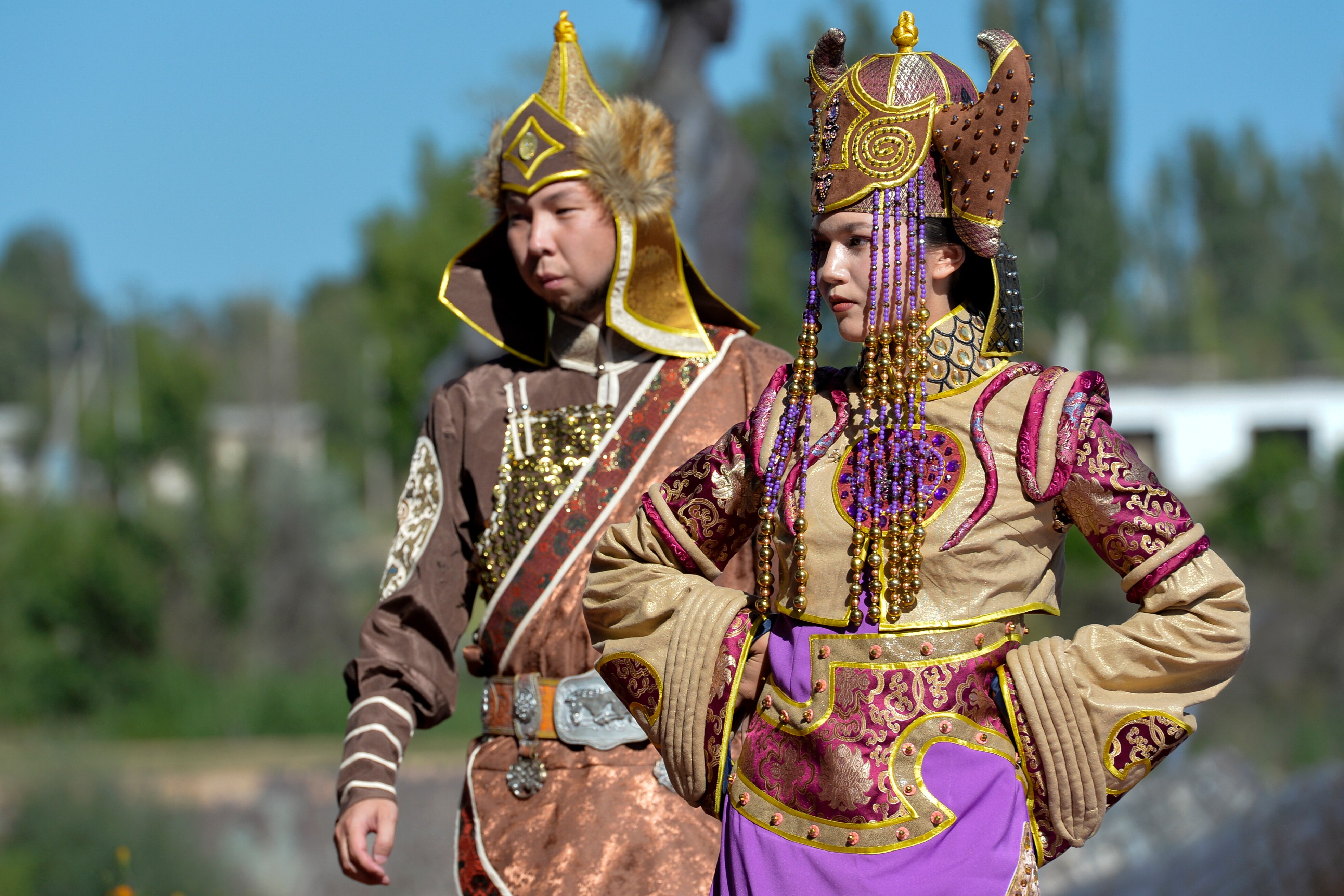 Two Members of the Russian Folk Dance Ensemble are dressed in colorful outfits and standing with their hands on hips. 