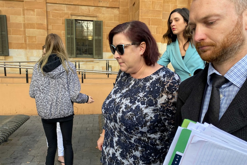 Catherine Jayne Moyse walks outside a courthouse next to a man
