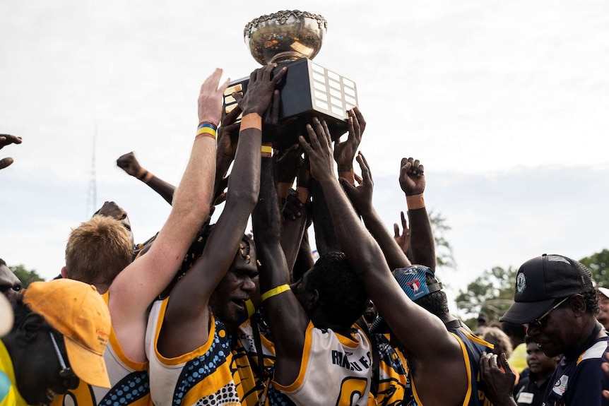 Ranku Eagles players raise the Tiwi premiership cup.